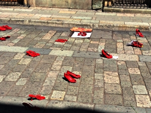 Empty red shoes cry out from the pavement. 